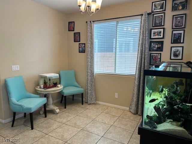 living area featuring a healthy amount of sunlight, light tile patterned floors, and a notable chandelier