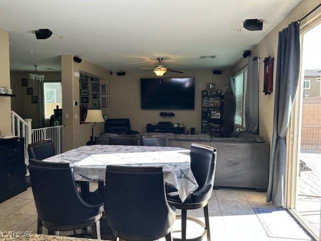 dining room featuring light tile patterned floors and ceiling fan with notable chandelier