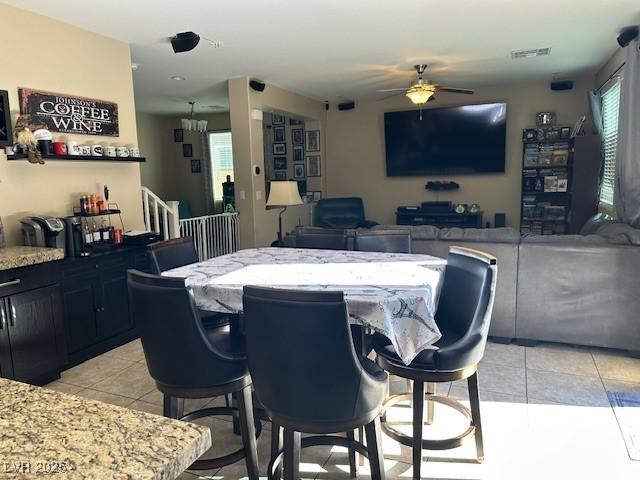 dining space with light tile patterned flooring and ceiling fan