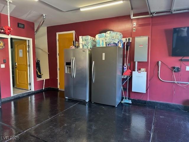 garage with stainless steel fridge with ice dispenser and stainless steel refrigerator