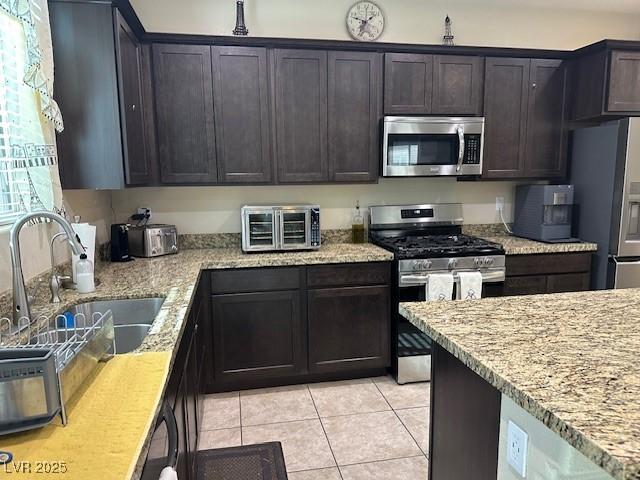 kitchen featuring sink, dark brown cabinets, stainless steel appliances, and a healthy amount of sunlight