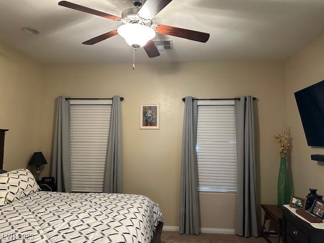 carpeted bedroom featuring visible vents, baseboards, and ceiling fan