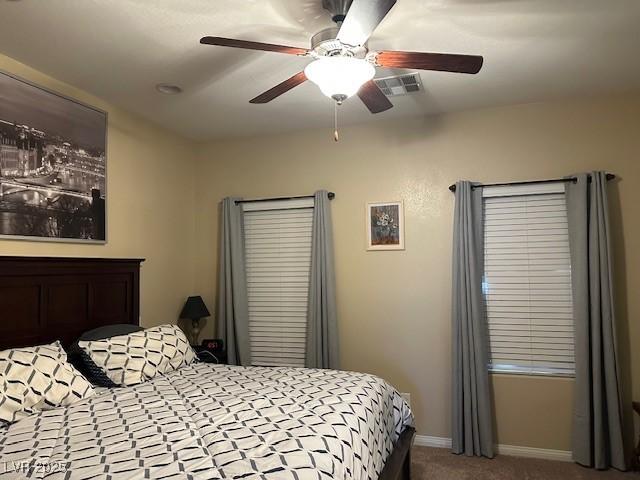 carpeted bedroom featuring baseboards, visible vents, and ceiling fan