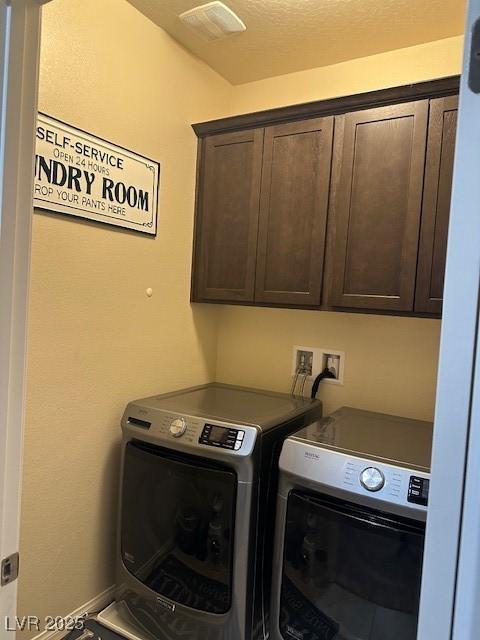 laundry room with separate washer and dryer, cabinet space, and visible vents