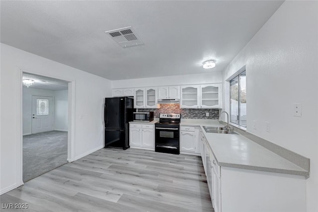 kitchen with white cabinets, sink, decorative backsplash, light wood-type flooring, and stainless steel appliances