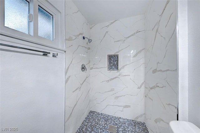 bathroom with tiled shower