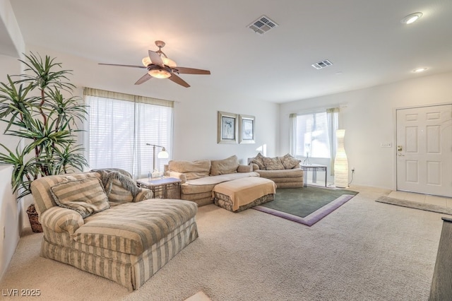 carpeted living room with ceiling fan