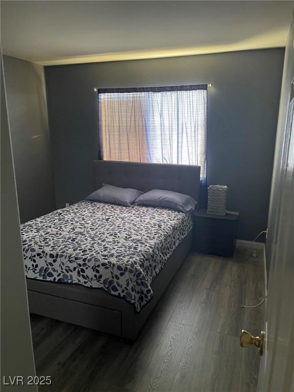 bedroom with dark wood-type flooring