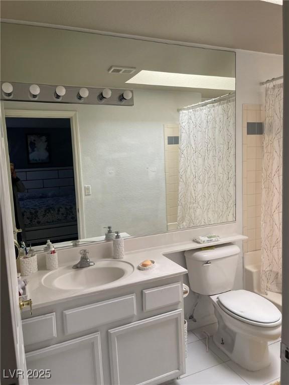 full bathroom featuring tile patterned floors, shower / tub combo with curtain, vanity, and toilet