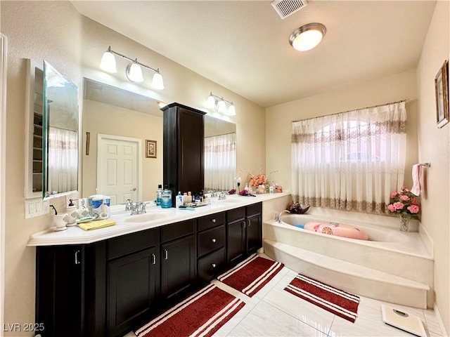 bathroom featuring vanity, tile patterned floors, and a bathtub