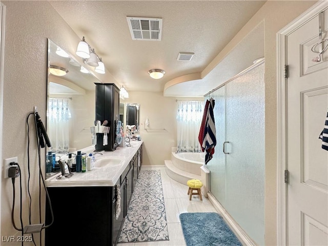 bathroom featuring tile patterned flooring, vanity, independent shower and bath, and a textured ceiling