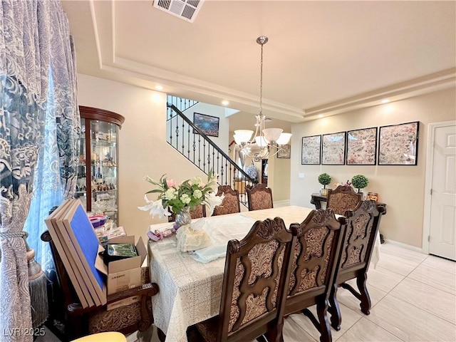 dining room with an inviting chandelier, light tile patterned floors, and a tray ceiling