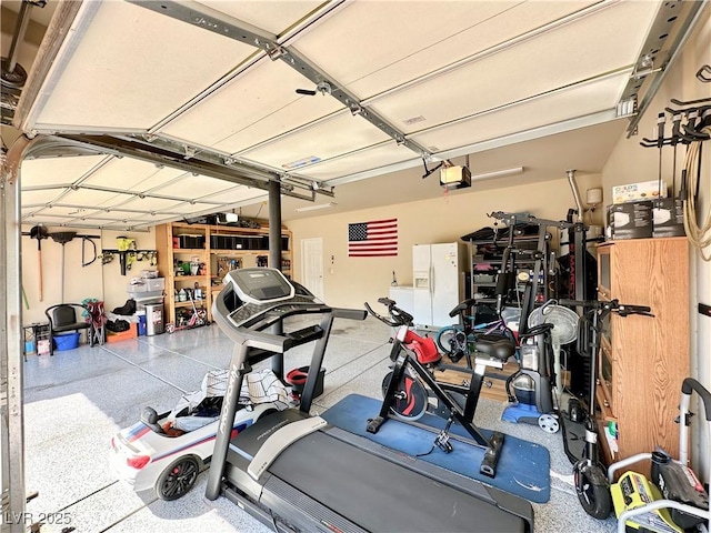 garage with a garage door opener and white fridge with ice dispenser