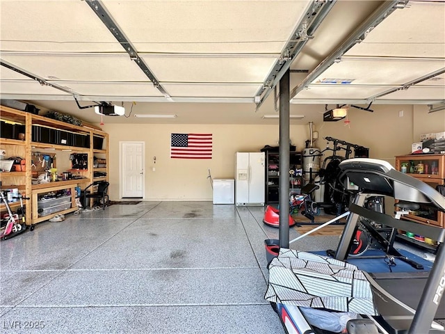 garage featuring a garage door opener and white fridge with ice dispenser