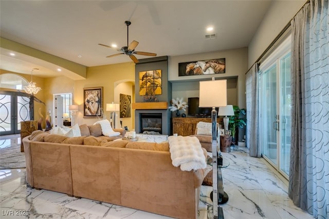 living room with a healthy amount of sunlight and ceiling fan with notable chandelier