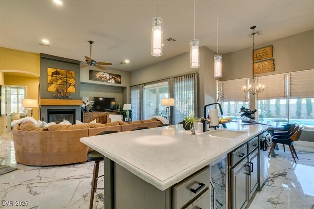 kitchen featuring pendant lighting, a center island with sink, a kitchen breakfast bar, and sink