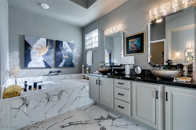 bathroom featuring vanity and tiled bath