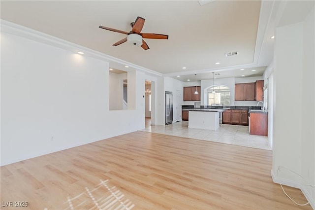 unfurnished living room with ceiling fan and light hardwood / wood-style flooring