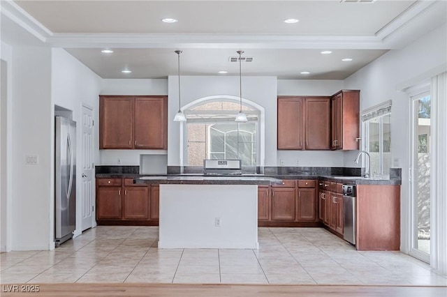 kitchen with appliances with stainless steel finishes, sink, plenty of natural light, and decorative light fixtures