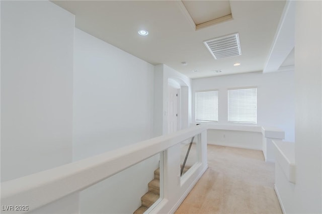 hallway featuring light colored carpet