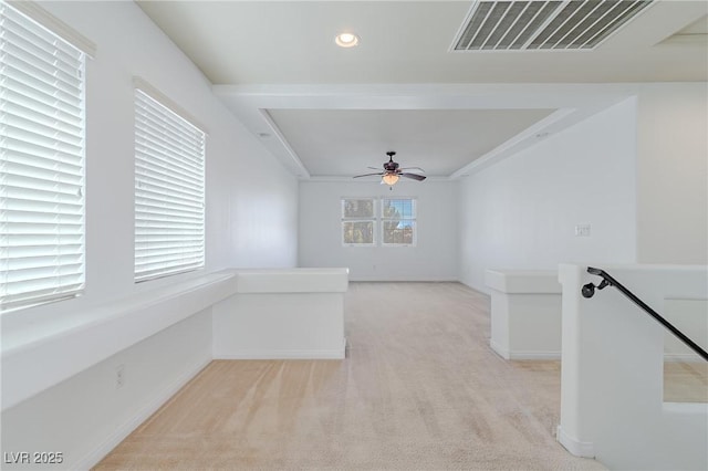 carpeted spare room featuring ceiling fan and a wealth of natural light