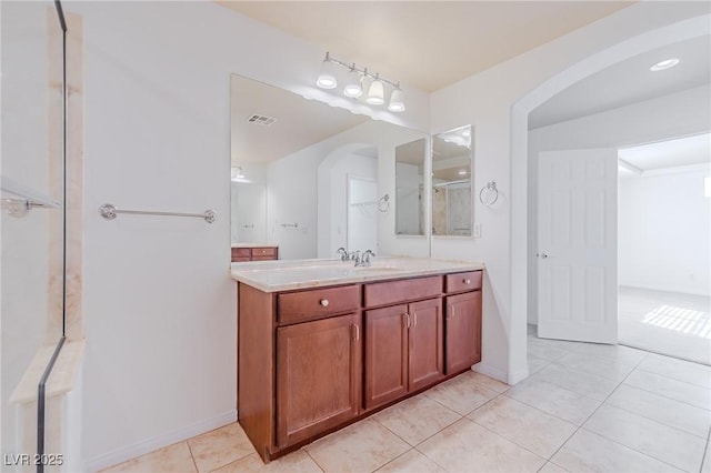 bathroom featuring walk in shower, vanity, and tile patterned flooring