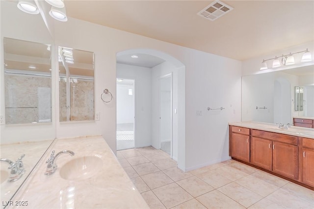 bathroom featuring a shower with shower door, tile patterned floors, and vanity