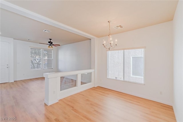 unfurnished room with wood-type flooring and ceiling fan with notable chandelier