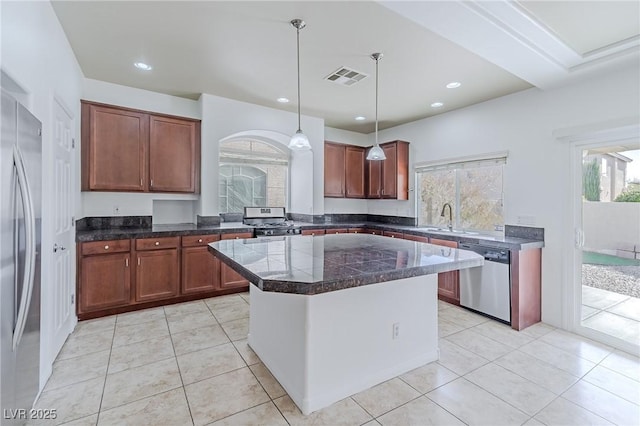 kitchen featuring a kitchen island, sink, hanging light fixtures, appliances with stainless steel finishes, and light tile patterned floors