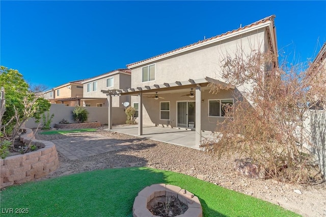 back of house featuring ceiling fan, a fire pit, and a patio