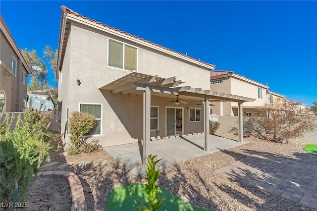 rear view of house with ceiling fan, a pergola, and a patio