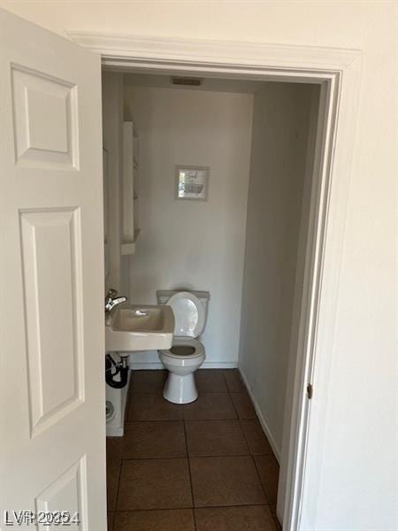 bathroom with tile patterned flooring, toilet, and sink