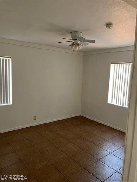 empty room featuring ceiling fan and crown molding