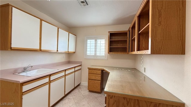 kitchen featuring white cabinets and sink