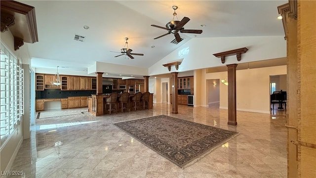 living room with ceiling fan, high vaulted ceiling, and decorative columns