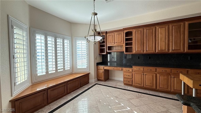 kitchen featuring tasteful backsplash, light tile patterned floors, pendant lighting, and a notable chandelier