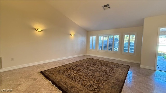 tiled empty room with lofted ceiling