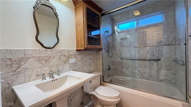 full bathroom with shower / bath combination with glass door, sink, toilet, tile walls, and tasteful backsplash