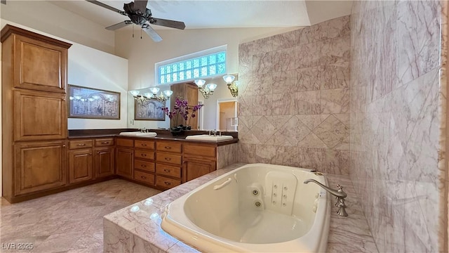 bathroom featuring vanity, ceiling fan with notable chandelier, and tiled tub