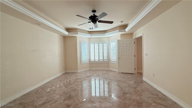 unfurnished room featuring a tray ceiling, ceiling fan, and crown molding