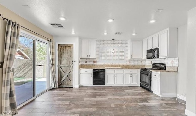 kitchen featuring pendant lighting, backsplash, black appliances, white cabinets, and sink