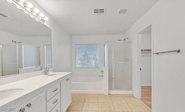 bathroom with tile patterned floors, vanity, and plus walk in shower