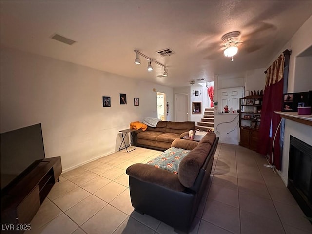 living room with light tile patterned flooring and track lighting