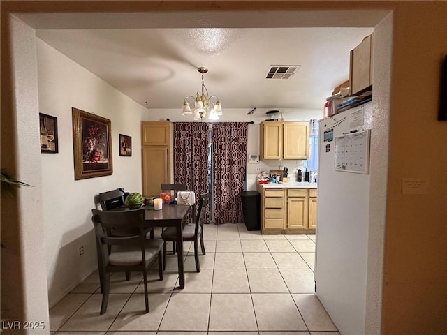 tiled dining area with a chandelier