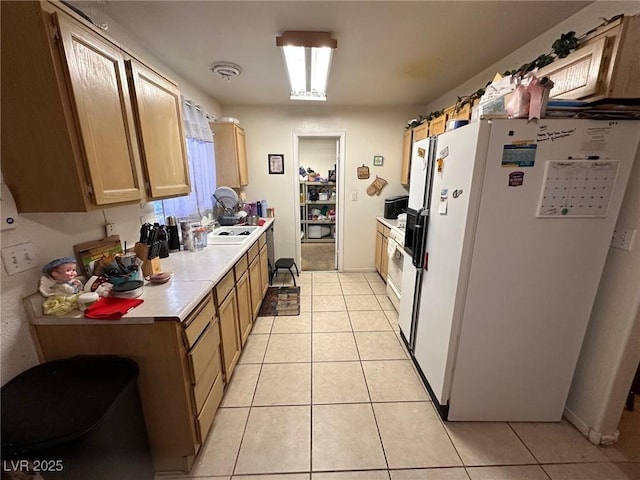 kitchen with sink, light tile patterned floors, and white refrigerator