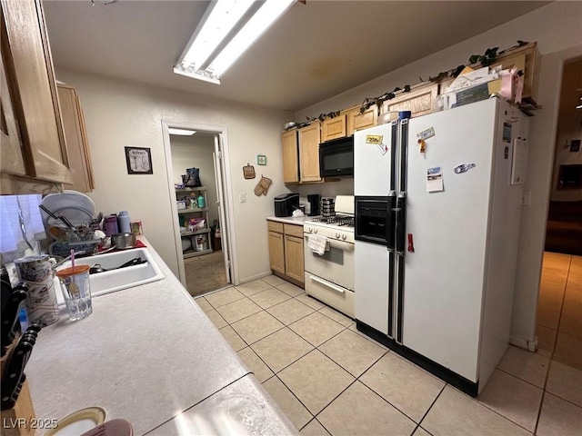 kitchen featuring light tile patterned flooring, white appliances, and sink