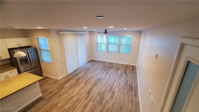 11251 Hidden Peak Ave Unit 212, Las Vegas, NV 89135 - unfurnished living room with light wood-type flooring, baseboards, a ceiling fan, and recessed lighting