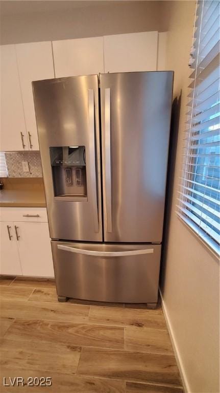 kitchen featuring white cabinetry, stainless steel fridge, and light hardwood / wood-style flooring