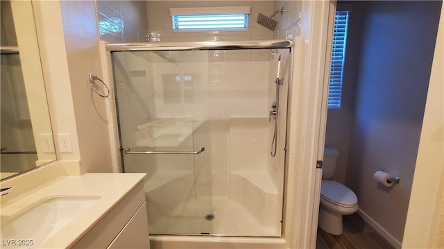 bathroom featuring hardwood / wood-style floors, vanity, toilet, and a shower with door