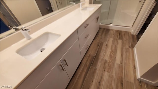 11251 Hidden Peak Ave Unit 212, Las Vegas, NV 89135 - bathroom featuring a shower stall, wood finished floors, double vanity, and a sink